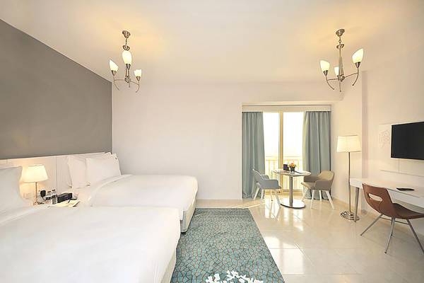 Jannah Hotels Resorts & Villas Zimmer mit zwei Betten, Schreibtisch und Balkon