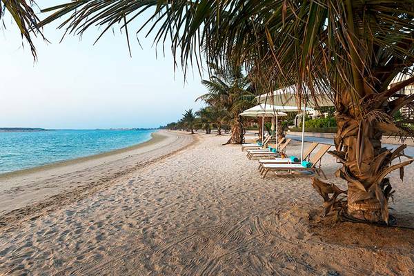 Strandszene mit Lounge-Liegestühlen und Palmen im Jannah Hotels Resorts & Villas