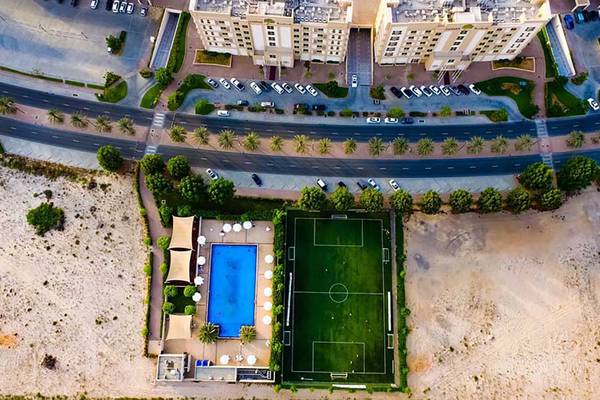 Aussenansicht des Jannah Hotels Resorts & Villas mit Swimmingpool und Fussballplatz.