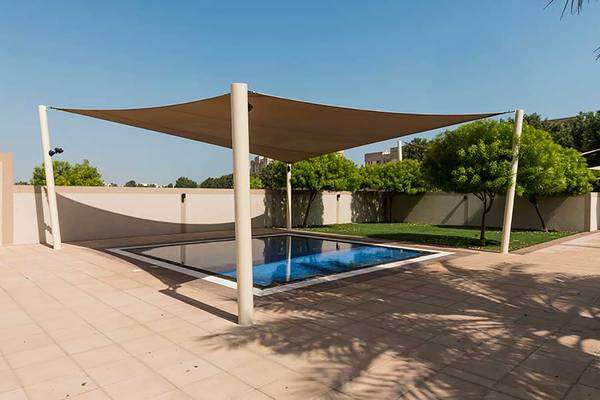Ein Swimmingpool mit einem Sonnensegel im Außenbereich eines Jannah Hotels Resorts & Villas.