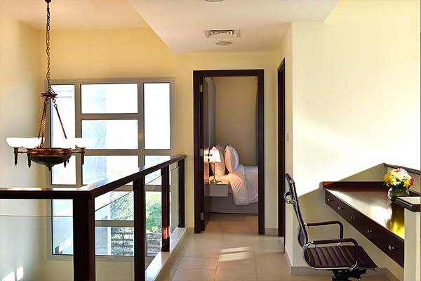 Innenansicht eines Zimmers in Jannah Hotels Resorts & Villas mit Schreibtisch, Stuhl und Bett.