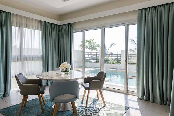 Jannah Hotels Resorts & Villas Innenbereich mit Esstisch und Terrasse