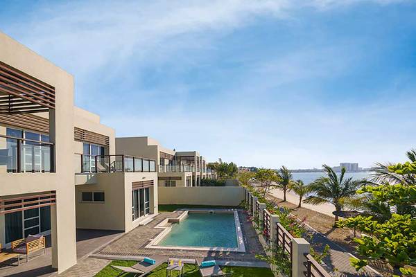 Außenbereich des Jannah Hotels Resorts & Villas mit Swimmingpool und Blick auf das Meer.