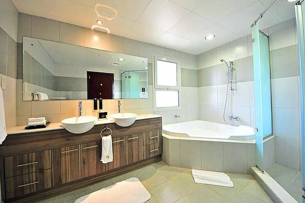 Badezimmer in Jannah Hotels Resorts & Villas mit Badewanne, Waschbecken und Spiegel.