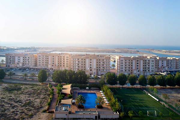 Luftaufnahme von Jannah Hotels Resorts & Villas mit Swimmingpool, Fußballfeld und Meer im Hintergrund.