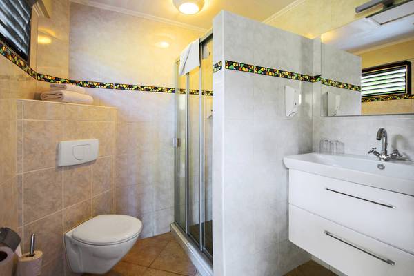 Badezimmer im LionsDive Beach Resort mit Dusche, Toilette und Waschbecken.