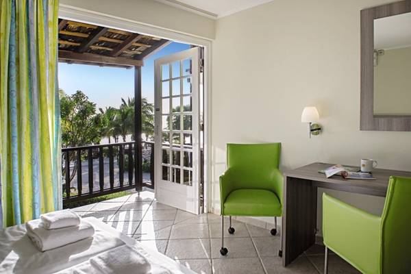 Zimmer im LionsDive Beach Resort mit Balkon und Blick auf die Außenlandschaft.