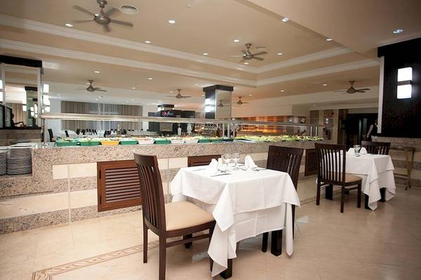 Innenansicht des Restaurants im Riu Naiboa Hotel mit leeren Tischen und Buffet.