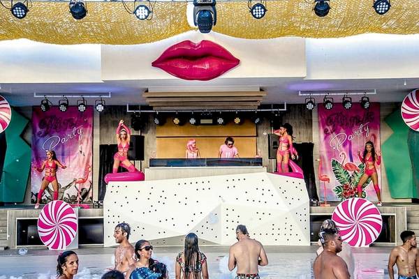 Darbietung der Pink Party Show im Riu Naiboa Hotel mit Darstellern auf der Bühne und Publikum im Wasser.