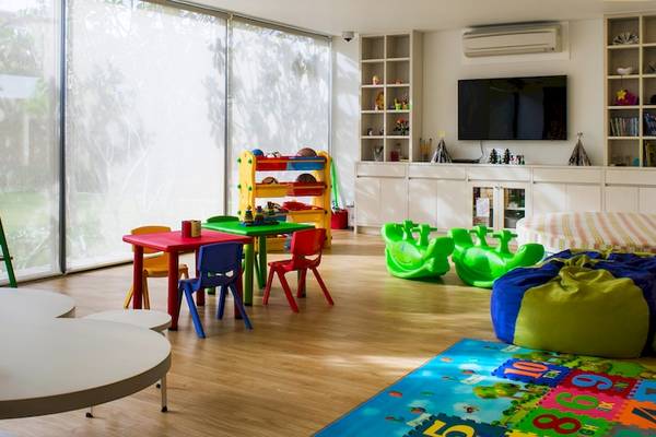 Kinderzimmer im Salinda Resort Phu Quoc Island mit bunten Möbeln, Teppich und Fernseher.