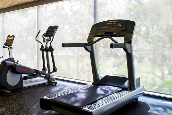 Fitnessstudio im Salinda Resort auf Phu Quoc Island mit mehreren Trainingsgeräten und großen Fenstern.