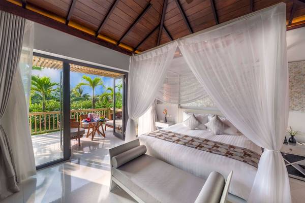 Schlafzimmer mit Bett, Balkon und Aussicht auf tropische Landschaft im Salinda Resort Phu Quoc Island