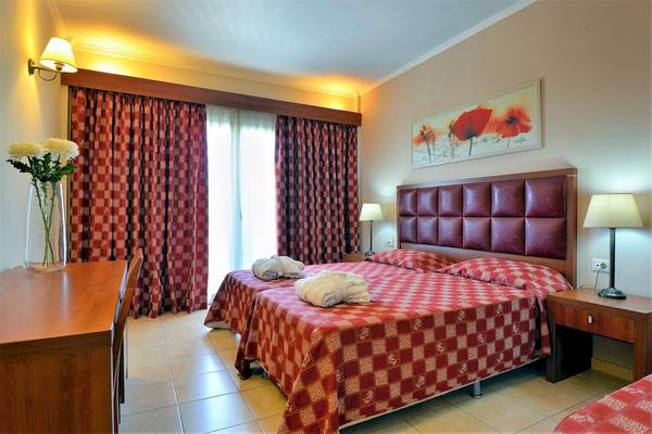 Doppelzimmer im Ariti Grand Hotel Corfu mit zwei Betten, roten Vorhängen und Kunstwerk an der Wand.