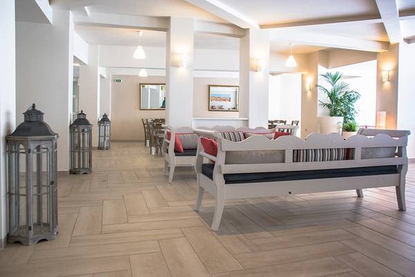 Innenbereich des Messonghi Beach Holiday Resort mit weißen Möbeln und Holzboden.