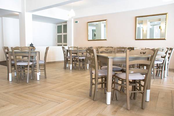 Innenansicht des Speisebereichs im Messonghi Beach Holiday Resort mit holzigen Tisch und Stühlen