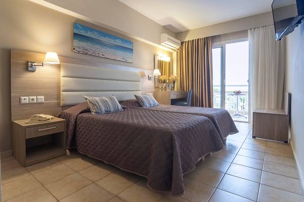 Doppelzimmer im Messonghi Beach Holiday Resort mit zwei Betten, Schreibtisch und Balkon.