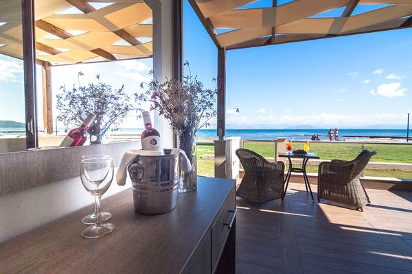 Terrasse im Messonghi Beach Holiday Resort mit Blick auf das Meer und zwei Stühle.