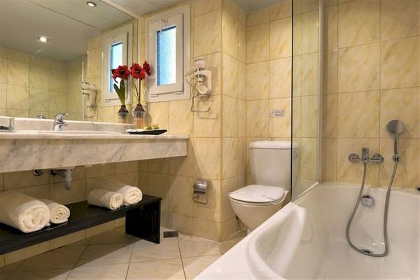 Badezimmer im Ariti Grand Hotel Corfu mit Badewanne, Dusche, Toilette und Waschbecken.