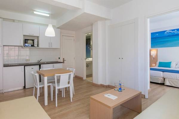 Innenansicht des Whala Beach Hotel Zimmers mit Küchenzeile, Esstisch, Sofa und Schlafzimmerbereich.