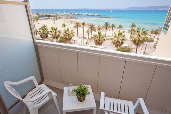 Ein Balkon mit Aussicht auf einen Strand und einen Hafen, vom Whala Beach Hotel.