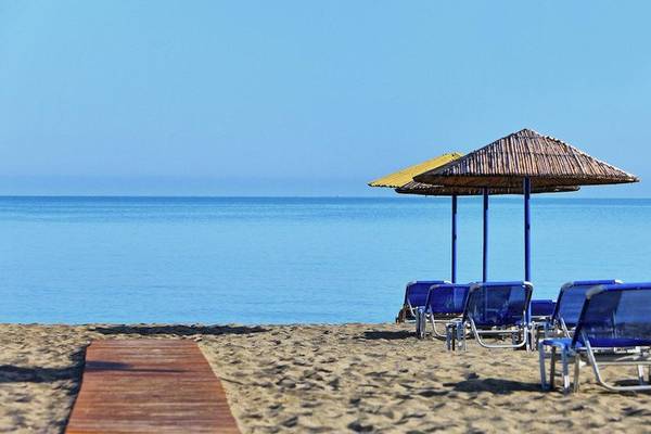 Strandszene mit Sonnenliegen und Sonnenschirmen am Giannoulis Santa Marina Beach Hotel.