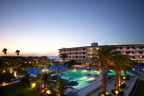 Außenbereich des Mitsis Ramira Beach Hotels mit Swimmingpool und Sonnenschirmen.