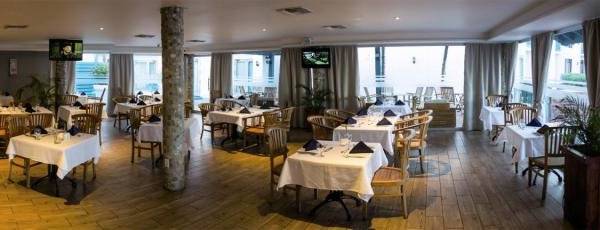 Das geräumige Restaurant des Mill Resort & Suites mit vielen Tischen und Stühlen.