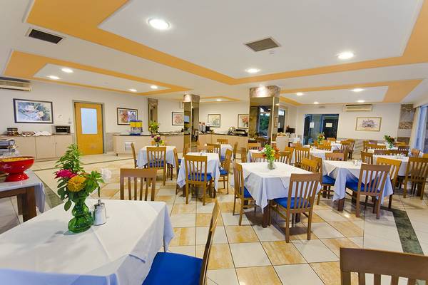 Innenansicht des Restaurants im Kosta Palace City Hotel mit gedeckten Tischen und Stühlen.