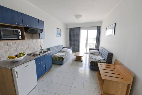 Innenansicht eines Zimmers im Kosta Palace City Hotel mit Küchenbereich und Schlafsofas.