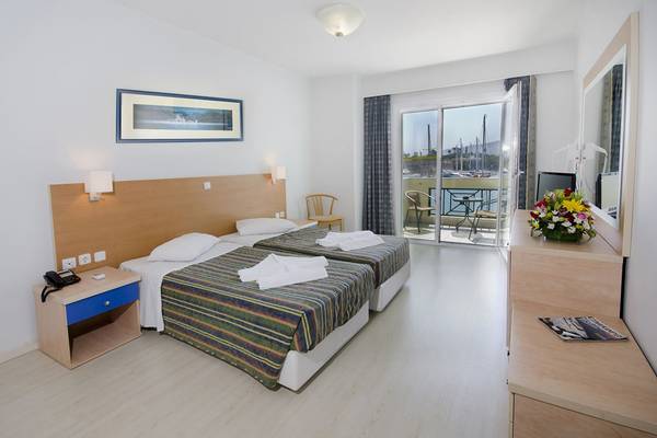 Doppelzimmer im Kosta Palace City Hotel mit zwei Betten, einem Balkon und Meerblick.