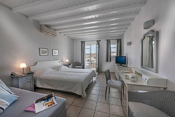 Doppelzimmer im Deliades Hotel mit zwei Betten, Schreibtisch und Fernseher.