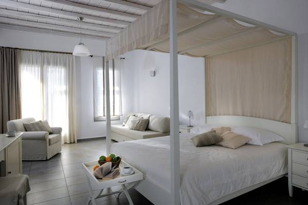 Schlafzimmer mit Baldachin-Bett, Sofa und Esstisch im Deliades Hotel.