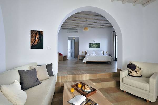 Innenansicht des Deliades Hotels mit Wohnzimmer, Schlafsofa, Couchtisch und Frühstückstablett.