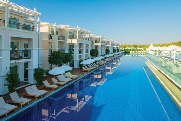 Außenpool des Titanic Deluxe Golf Belek Hotels mit Loungestühlen und Sonnenschirmen