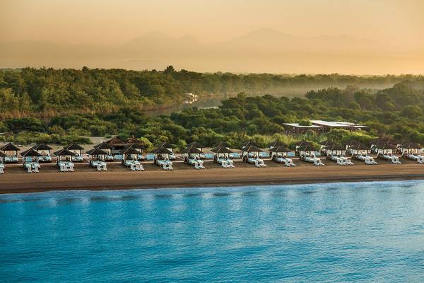 Luftaufnahme des Titanic Deluxe Golf Belek Strandes mit vielen Sonnenliegen und Zelten