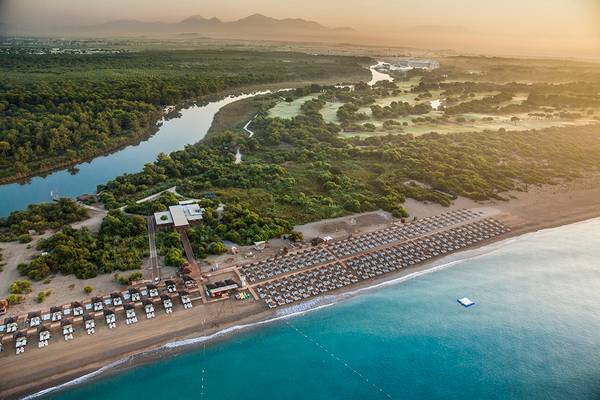Luftaufnahme des Titanic Deluxe Golf Belek mit Strand, Fluss und Golfplatz
