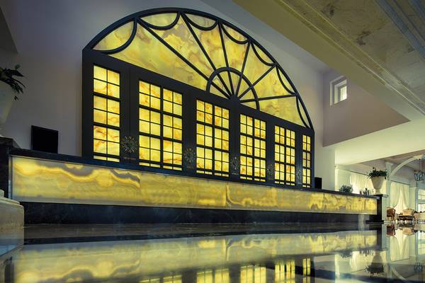 Empfangsbereich des Titanic Deluxe Golf Belek Hotels mit großem Fenster und gelben Marmor.