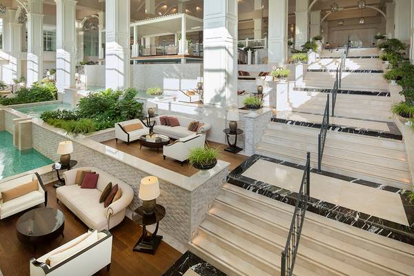 Innenbereich des Titanic Deluxe Golf Belek Hotels mit Empfangshalle, Sofas, Terrasse und Treppen.