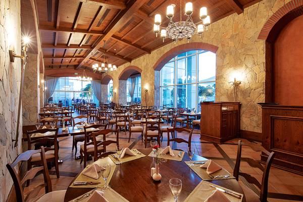 Innenansicht des Restaurants im Titanic Deluxe Golf Belek Hotel mit runden Tischen und Stühlen.