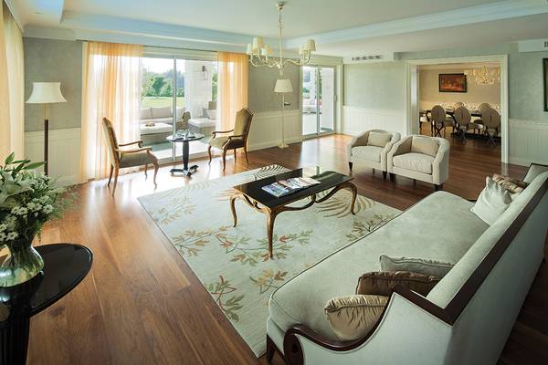 Wohnzimmer des Titanic Deluxe Golf Belek Hotels mit Sofa, Tisch, Stühlen und Dekoration.