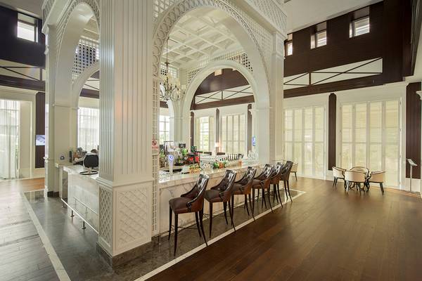 Barbereich des Titanic Deluxe Golf Belek Hotels mit weißen Säulen und Lederstühlen.