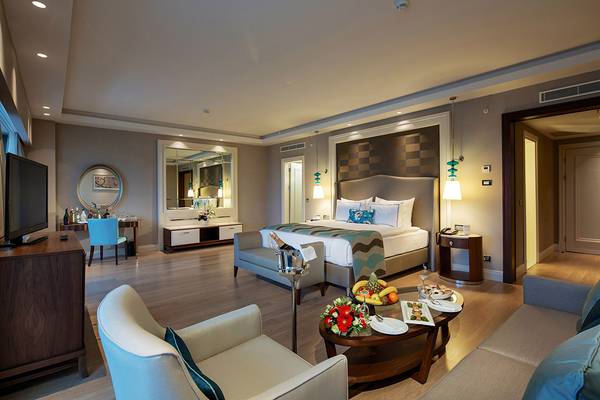 Innenansicht einer Suite im Titanic Deluxe Golf Belek Hotel mit Bett, Schreibtisch und Fernseher