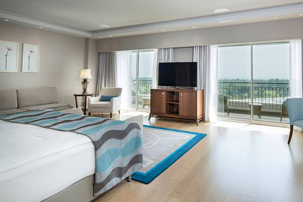 Hotelsuite Zimmer des Titanic Deluxe Golf Belek mit Aussicht auf Golfplatz und Landschaft.