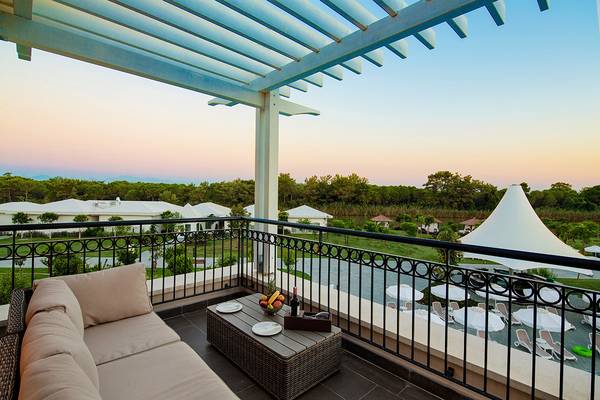 Terrasse des Titanic Deluxe Golf Belek Hotels mit Blick auf einen Garten und eine Lounge