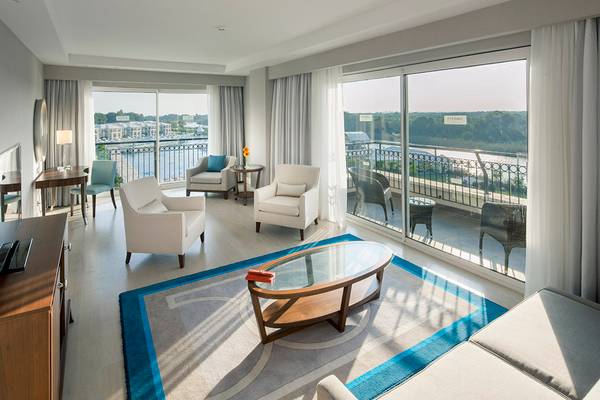 Innenansicht der Suite im Titanic Deluxe Golf Belek Hotel mit Blick auf den Balkon und Fluss.