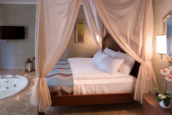 Ein Zimmer im Titanic Deluxe Golf Belek mit Bett, Whirlpool und Fernseher.