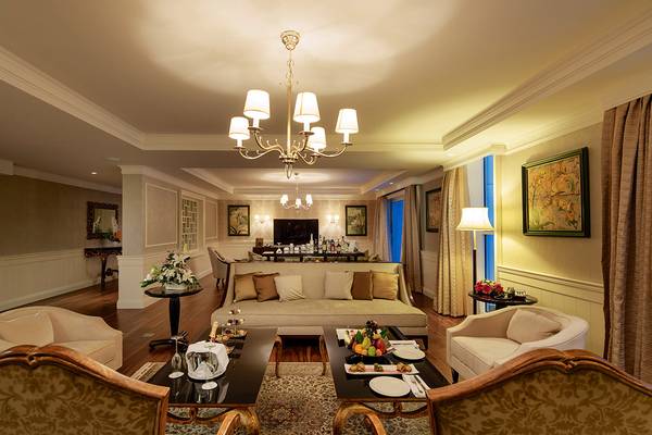Wohnzimmer der Suite im Titanic Deluxe Golf Belek mit Möbeln, Couch, Tisch und Lampe.