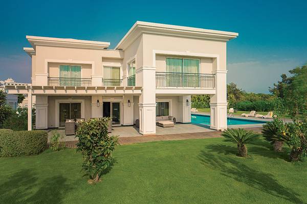 Außenansicht der Titanic Deluxe Golf Belek Villa mit Pool und Terrasse.