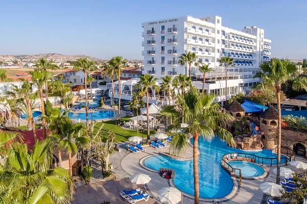 Luftaufnahme des Lordos Beach Hotel mit Swimmingpools, Sonnenliegen und Palmen.