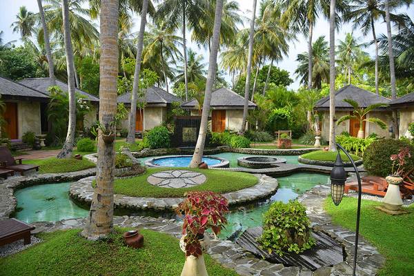 Außenbereich des Bandos Maldives Hotels mit kleinen Pools und tropischen Pflanzen.